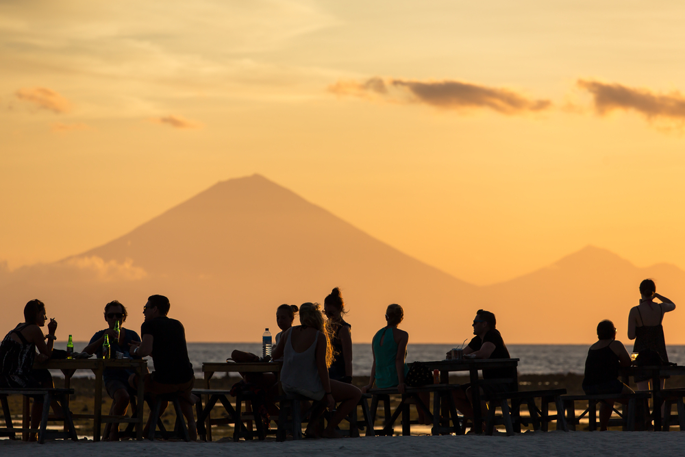 Wisatawan di Gili Trawangan melihat pemandangan matahari terbenam yang menghadap Gunung Agung